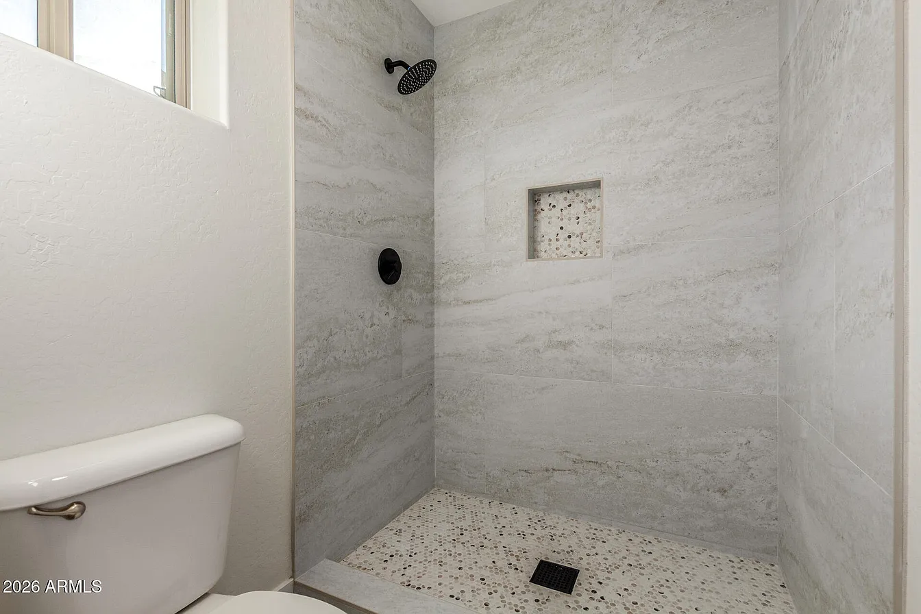 Custom tile shower with penny tile floor and glass enclosure