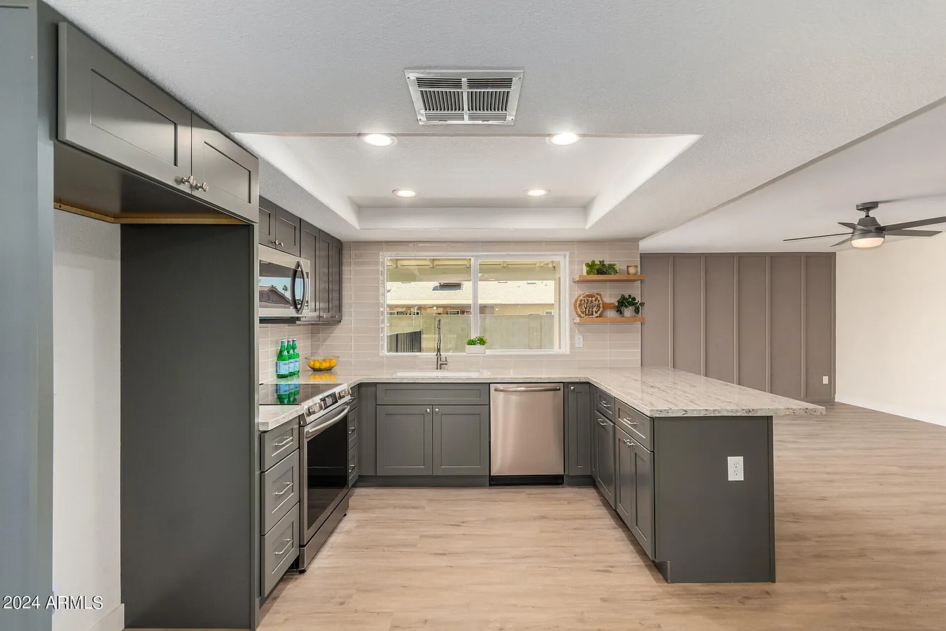 Gray shaker kitchen with tray ceiling and island